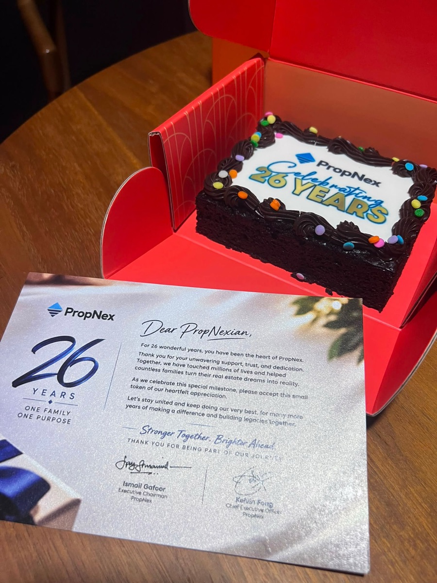 PropNex 26-year anniversary card next to the celebration cake